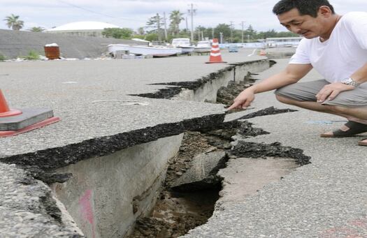 Un residente muestra los daños de la vía al puerto de Makinohara, en Shizuoka, Japón central, después del terremoto de 6.6 grados de magnitud. 