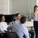 Una empleada tímida, nerviosa y tímida se siente avergonzada y temerosa de hablar en público en la reunión del equipo del grupo corporativo, una mujer tímida y estresada que oculta la cara durante un momento incómodo al informar en el cargo