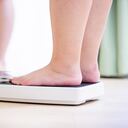 talla grande mira en el espejo y mide su peso por báscula obesidad salud