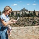 Turista alegre usando un mapa en la ciudad de Toledo, España