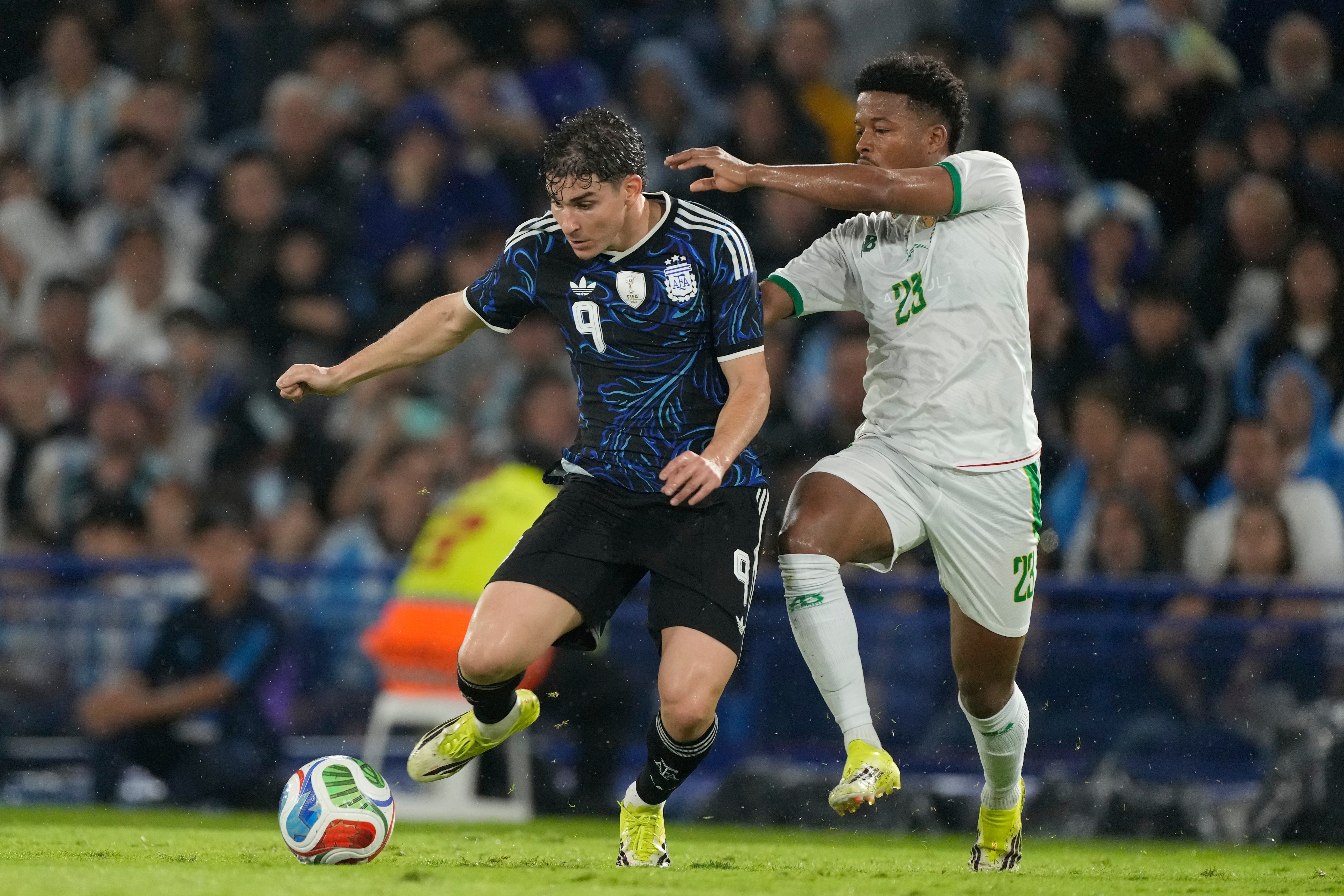 Julián Álvarez, de Argentina, y Beyatt Lekweiry, de Mauritania, luchan por el balón durante un partido amistoso de fútbol en Buenos Aires, Argentina.