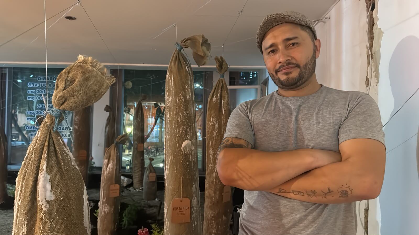 El artista bogotano Diego Díaz Sabogal posa junto a parte de la instalación ‘Salario Mínimo'.
