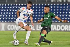 El mediocampista argentino de Nacional Juan Fernando Alfaro (i) y el mediocampista del Atlético Nacional Robert Mejía (d) luchan por el balón durante el partido de ida de la segunda ronda de la Copa Libertadores entre Nacional de Paraguay y Atlético Nacional de Colombia en el estadio Defensores del Chaco en Asunción en febrero 21 de diciembre de 2024. (Foto de NORBERTO DUARTE / AFP)
