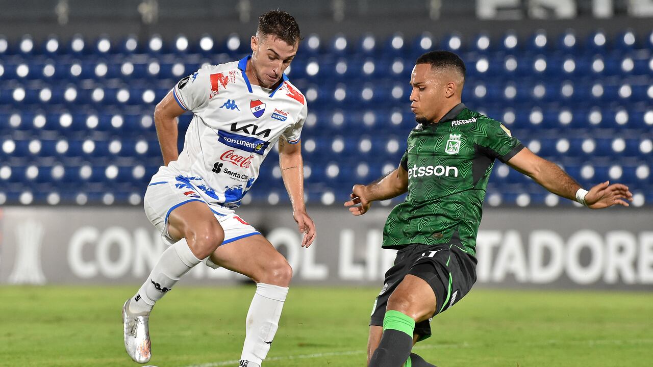 El mediocampista argentino de Nacional Juan Fernando Alfaro (i) y el mediocampista del Atlético Nacional Robert Mejía (d) luchan por el balón durante el partido de ida de la segunda ronda de la Copa Libertadores entre Nacional de Paraguay y Atlético Nacional de Colombia en el estadio Defensores del Chaco en Asunción en febrero 21 de diciembre de 2024. (Foto de NORBERTO DUARTE / AFP)