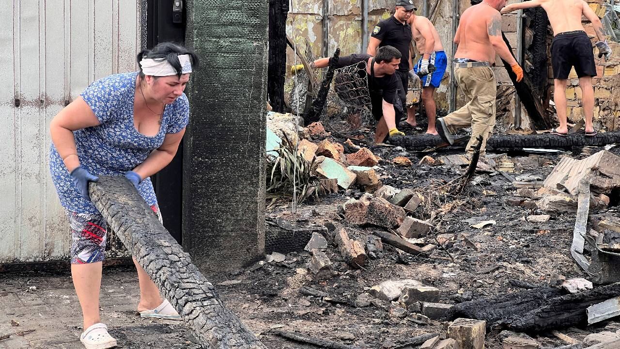 Los residentes retiran los escombros de los edificios dañados por un ataque con misiles rusos.