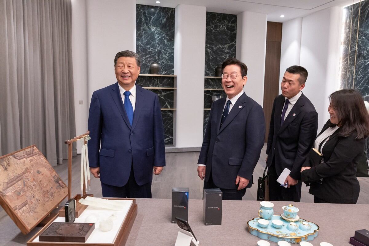 El presidente chino Xi Jinping (izq.) intercambiando obsequios durante una reunión paralela a la Cumbre de Cooperación Económica Asia-Pacífico (APEC) en Gyeongju.
