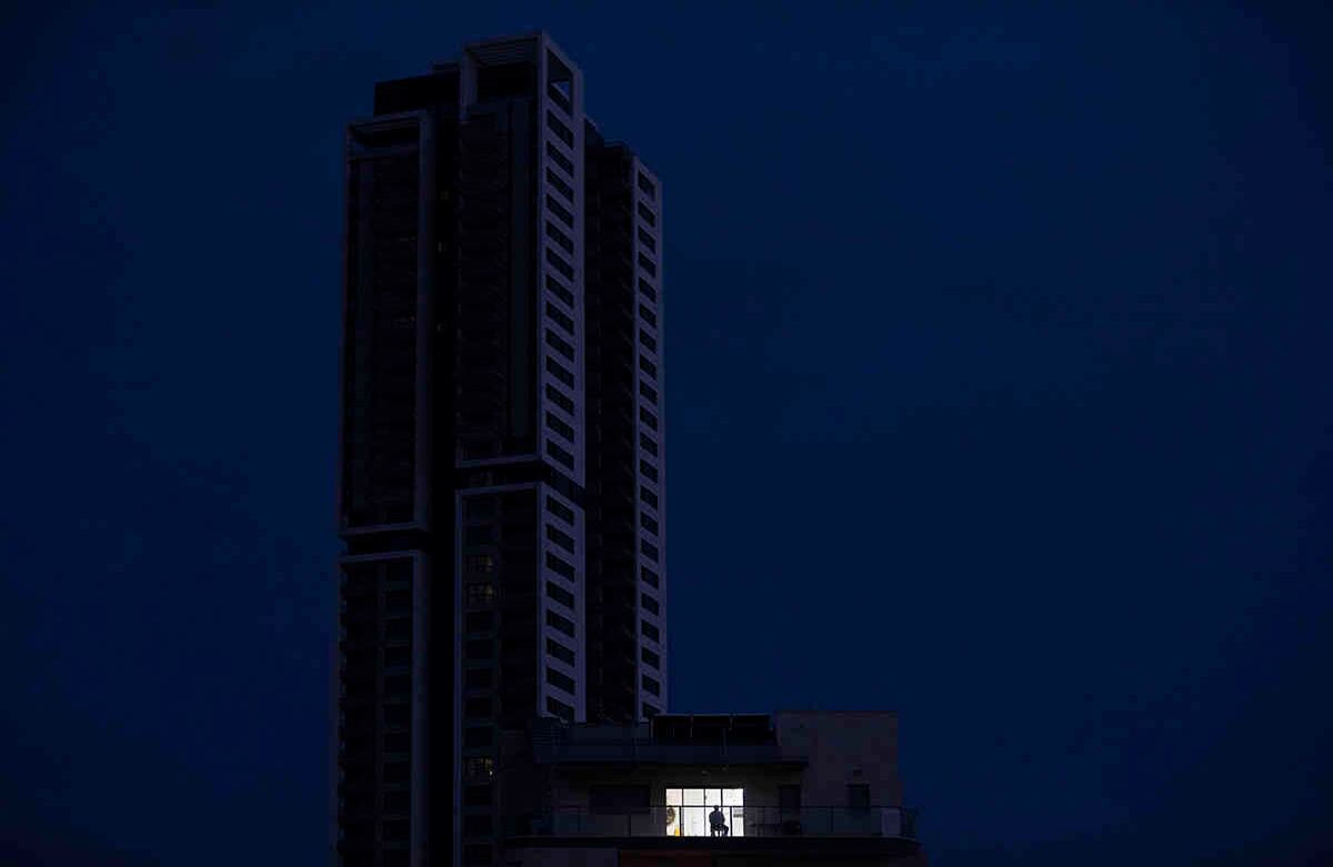 Un hombre se sienta en su balcón durante el aislamiento, siguiendo las medidas del gobierno para ayudar a detener la propagación del coronavirus en Ramat Gan, Israel.  AP Photo/Oded Balilty