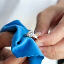Jeweller hand polishing and cleaning jewelry diamond ring with micro fiber fabric