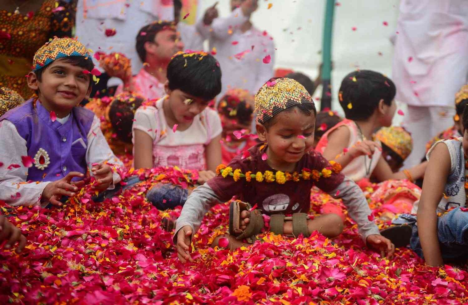 Niños indios juegan con pétalos de flores en un evento para celebrar el festival hindú de Holi para niños con parálisis cerebral organizado por la Fundación Trishla en Allahabad el 25 de febrero de 2018. / AFP PHOTO / SANJAY KANOJIA
