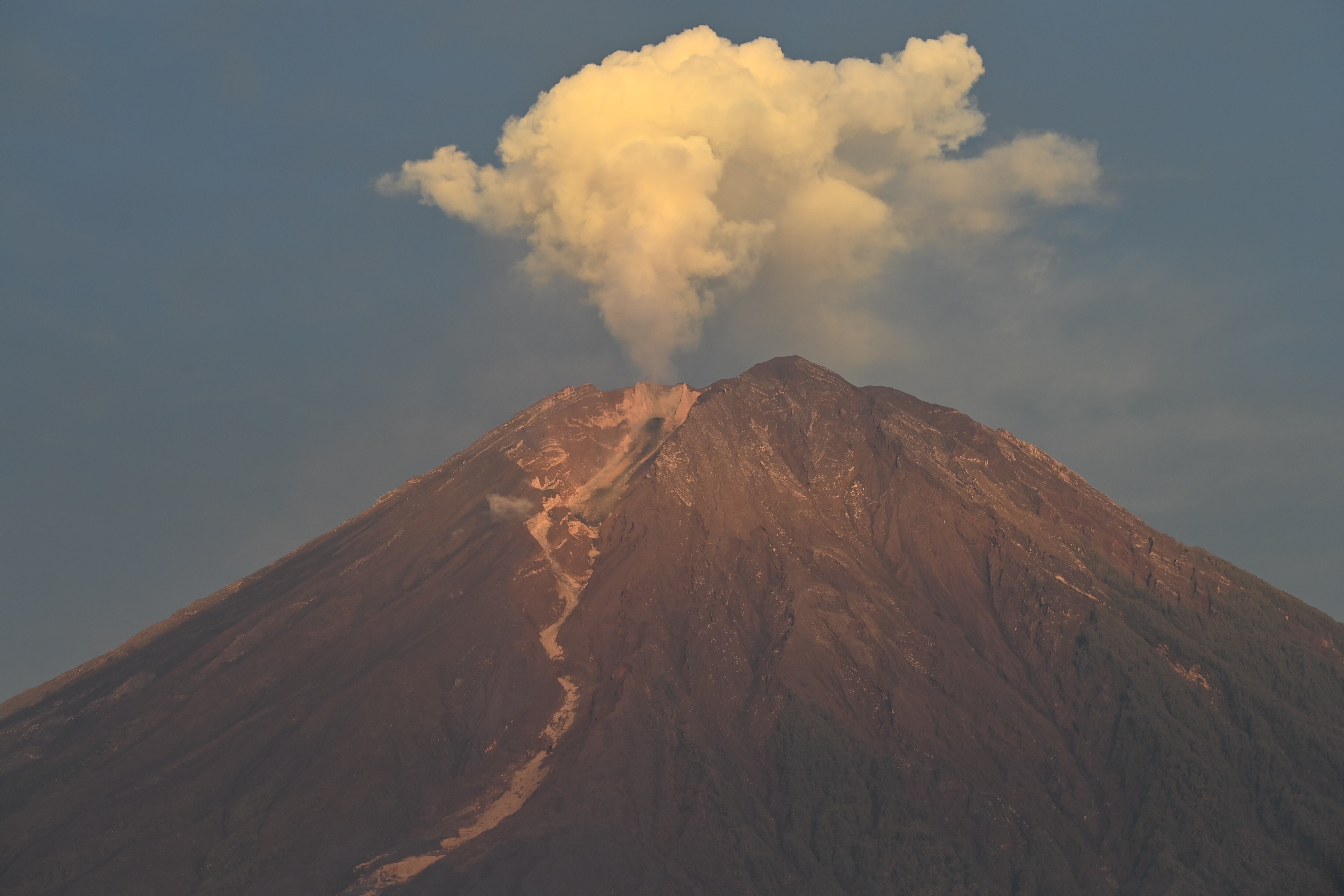El monte Semeru arroja un fino humo visto desde la aldea de Curah Kobokan en Lumajang el 8 de diciembre de 2021