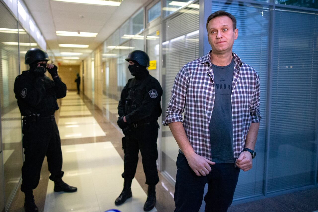 El líder de la oposición rusa Alexei Navalny habla con los medios frente a agentes de seguridad que hacen guardia