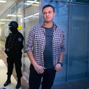 El líder de la oposición rusa Alexei Navalny habla con los medios frente a agentes de seguridad que hacen guardia