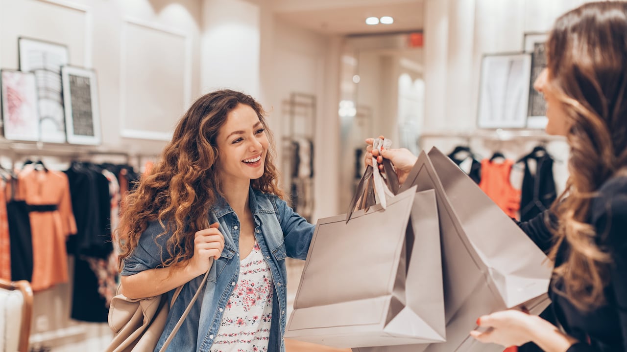 Young woman taking her shopping bags in a fashion store