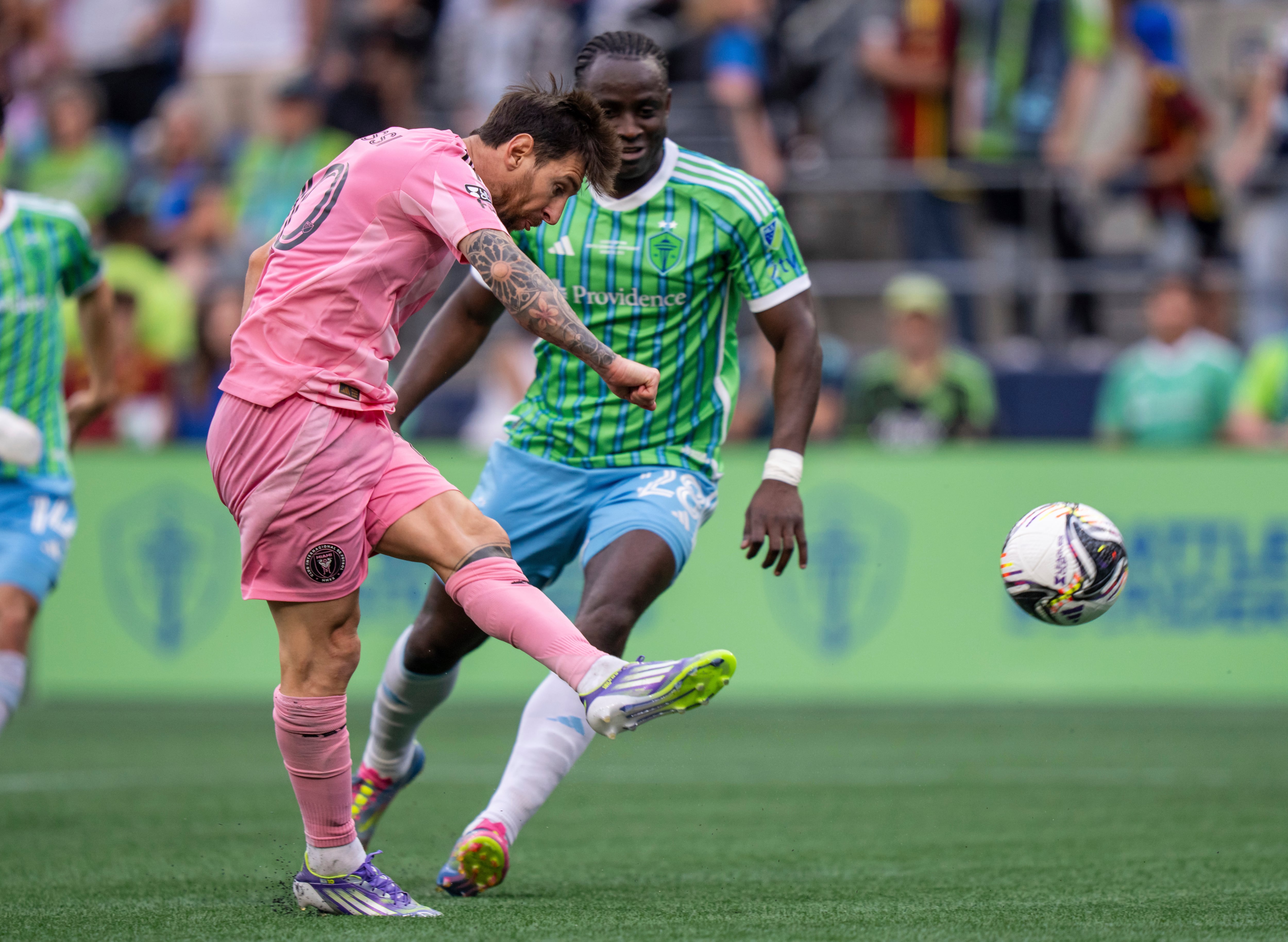 Inter Miami forward Lionel Messi, left, shoots against Seattle Sounders defender Yeimar Gomez, right, during the second half of the Leagues Cup final soccer match, Sunday, Aug. 31, 2025, in Seattle. (AP Photo/Stephen Brashear)