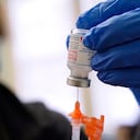 FILE - Pharmacist Kenni Clark prepares a booster dose of the Moderna COVID-19 vaccine during a vaccination clinic at City of Lawrence's "The Center," which serves seniors, families and the community, Wednesday, Dec. 29, 2021, in Lawrence, Mass. U.S. regulators, on Friday, Jan. 7, 2022, are shortening the time that people who received Moderna's COVID-19 vaccine have to wait for a booster — to five months rather than six. The Moderna vaccine is open to Americans 18 and older.(AP Photo/Charles Krupa, File)
