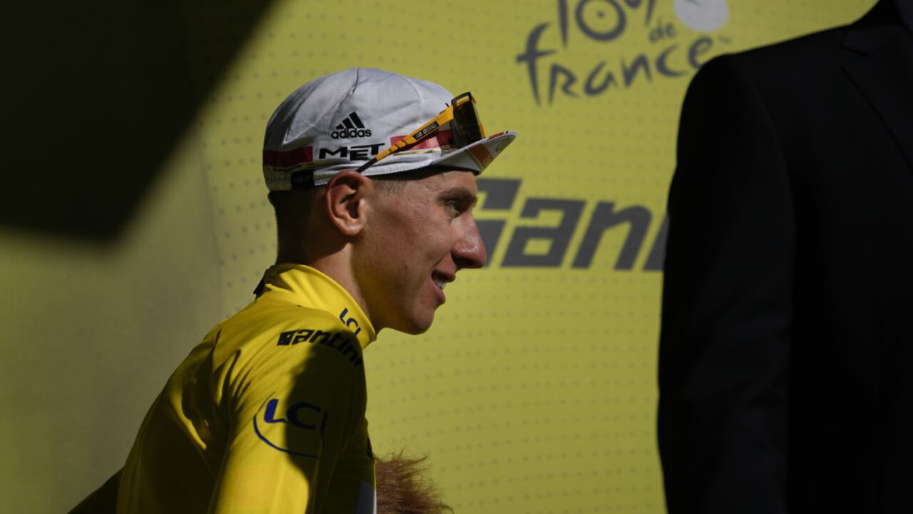 Slovenia's Tadej Pogacar, wearing the overall leader's yellow jersey, walks onto the podium after the ninth stage of the Tour de France cycling race over 193 kilometers (119.9 miles) with start in Aigle, Switzerland and finish in Chatel les Portes du Soleil, France, Sunday, July 10, 2022. (AP/Daniel Cole)