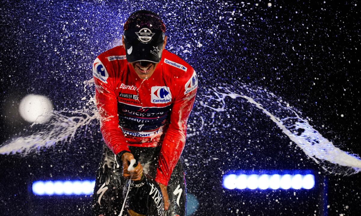 Belgian Remco Evenepoel of Quick-Step Alpha Vinyl celebrates by spraying cava on the podium after winning La Vuelta cycling race in Madrid, Spain, Sunday, Sept. 11, 2022. (AP/Manu Fernandez)