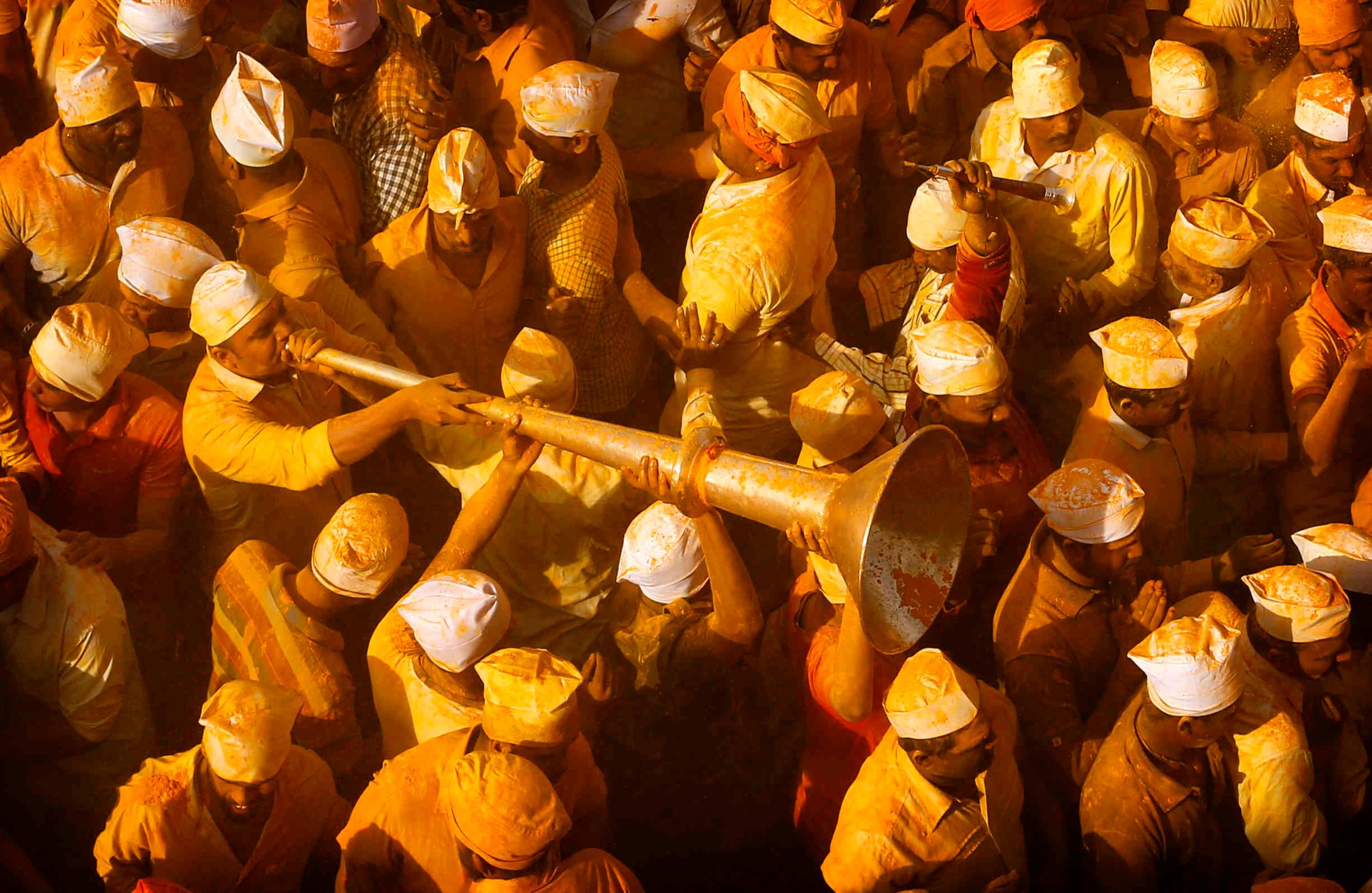 3 de junio - Un devoto toca un cuerno entre la multitud que se reunió durante la celebración del Festival de Bhandara, o el Festival de la Cúrcuma, en el templo de Jejuri en India. Durante el festival, los devotos usan el polvo dorado para adorar a la deidad, el Señor Khandoba, ampliamente conocido como descendiente del sol. FOTO: Rafiq Maqbool / AP