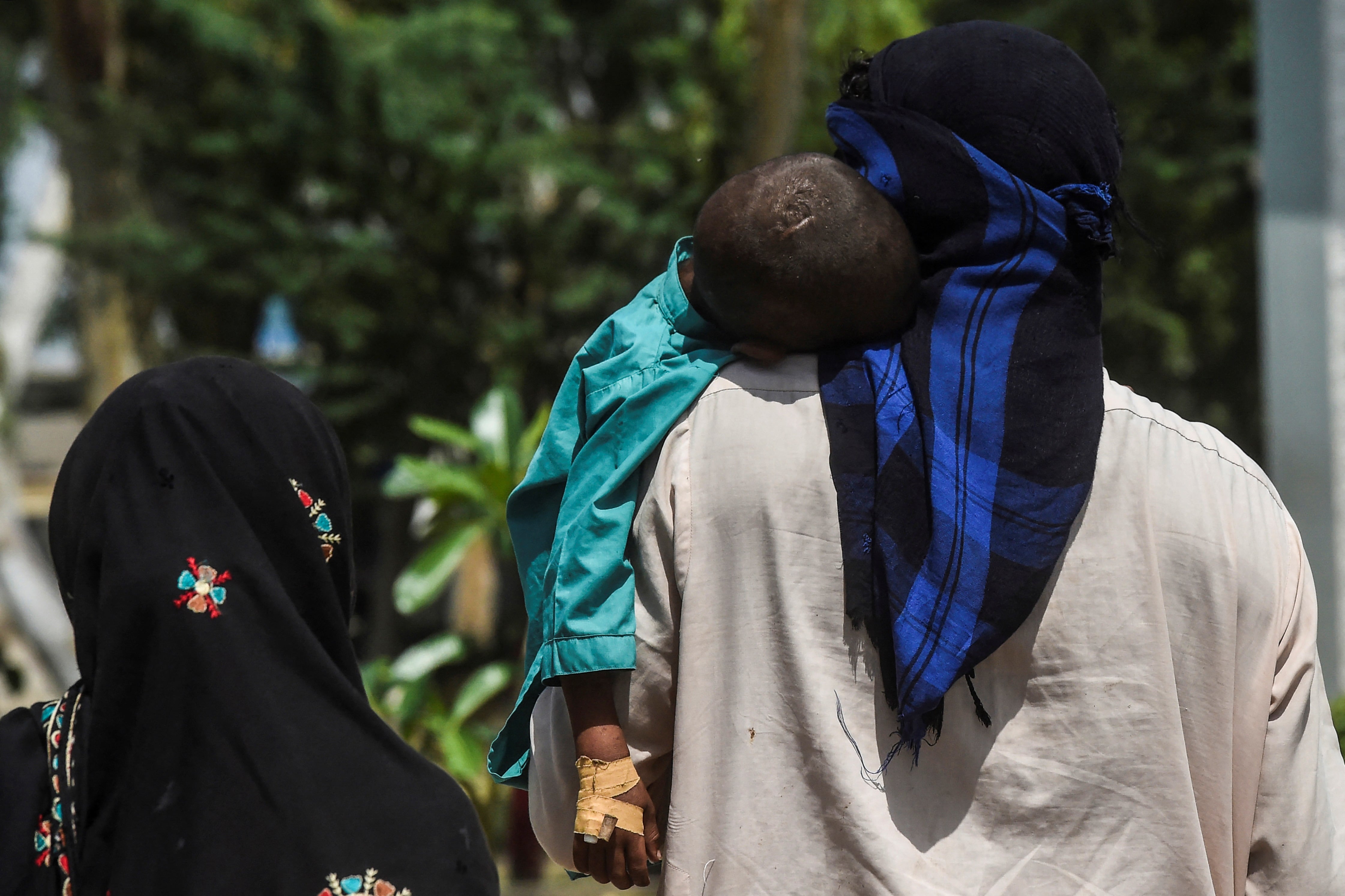 Un papá carga un pequeño seropositivo en Pakistán. (Photo by Asif HASSAN / AFP) / TO GO WITH Pakistan-health-HIV-children,FOCUS by Ashraf KHAN