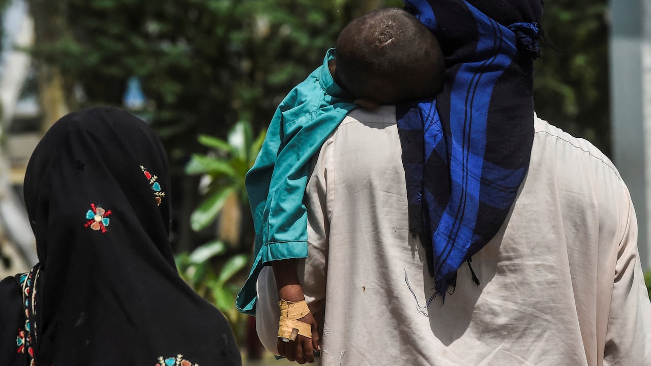 Un papá carga un pequeño seropositivo en Pakistán. (Photo by Asif HASSAN / AFP) / TO GO WITH Pakistan-health-HIV-children,FOCUS by Ashraf KHAN