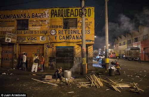Un indigente cocina en una fogata improvisada con madera que recogió de la calle. Foto: cortesía Juan Arredondo / DailyMail.