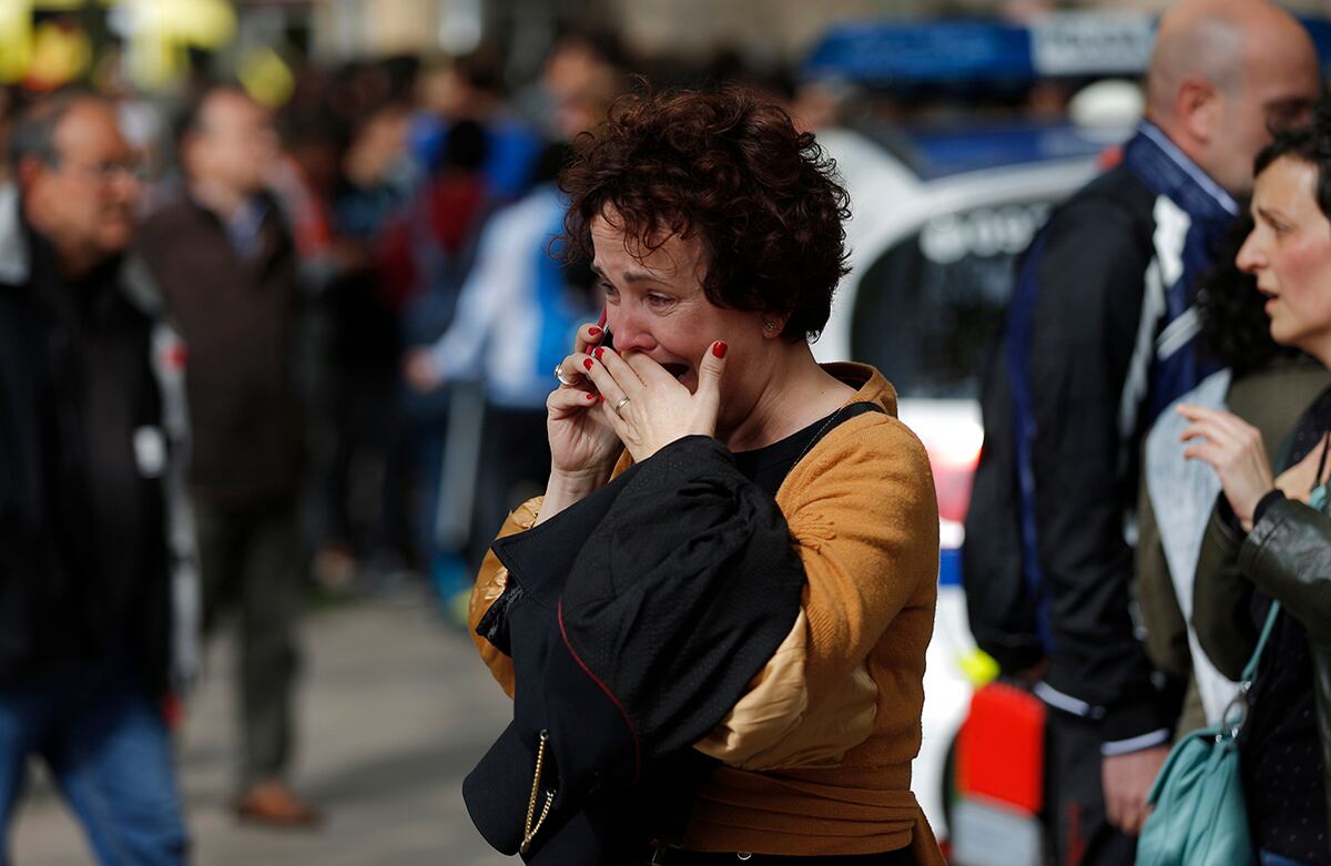 Una mujer habla por su celular fuera de una escuela en Barcelona, en donde un joven asesinó un maestro y atacó a varias otras personas antes de ser detenido por la policía de España. (AP)