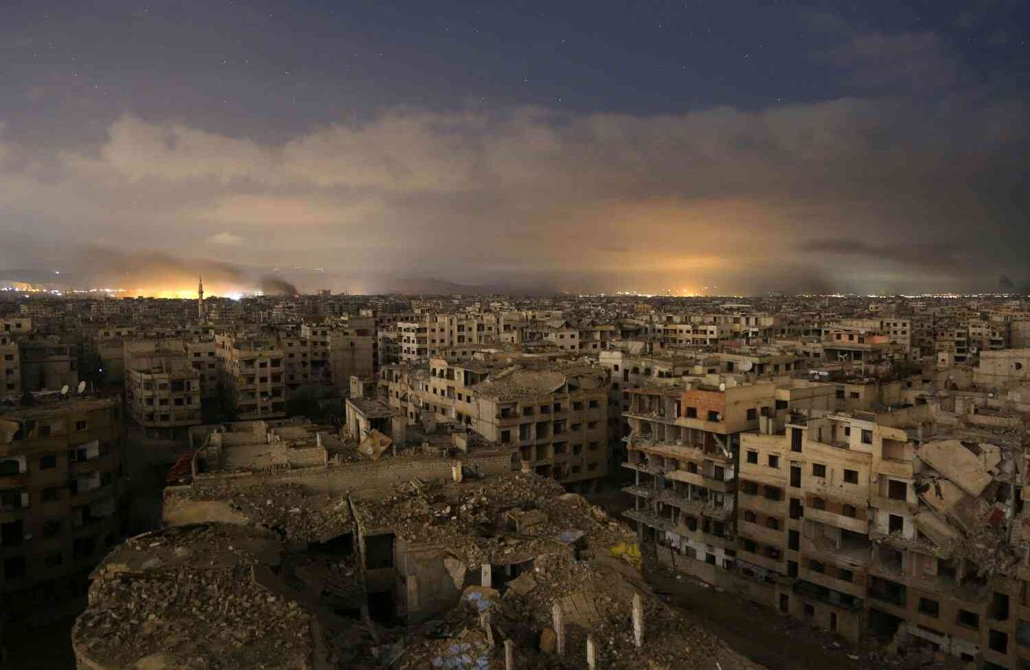 El cielo iluminado después de ataques aéreos del régimen en la sitiada región oriental de Ghouta, Damasco, el 23 de febrero de 2018. Los ataques del régimen sirio golpearon el enclave de Ghouta Oriental un sexto día consecutivo matando a 32 civiles, mientras el mundo luchaba por llegar a un acuerdo para detener la carnicería.  Ammar SULEIMAN / AFP