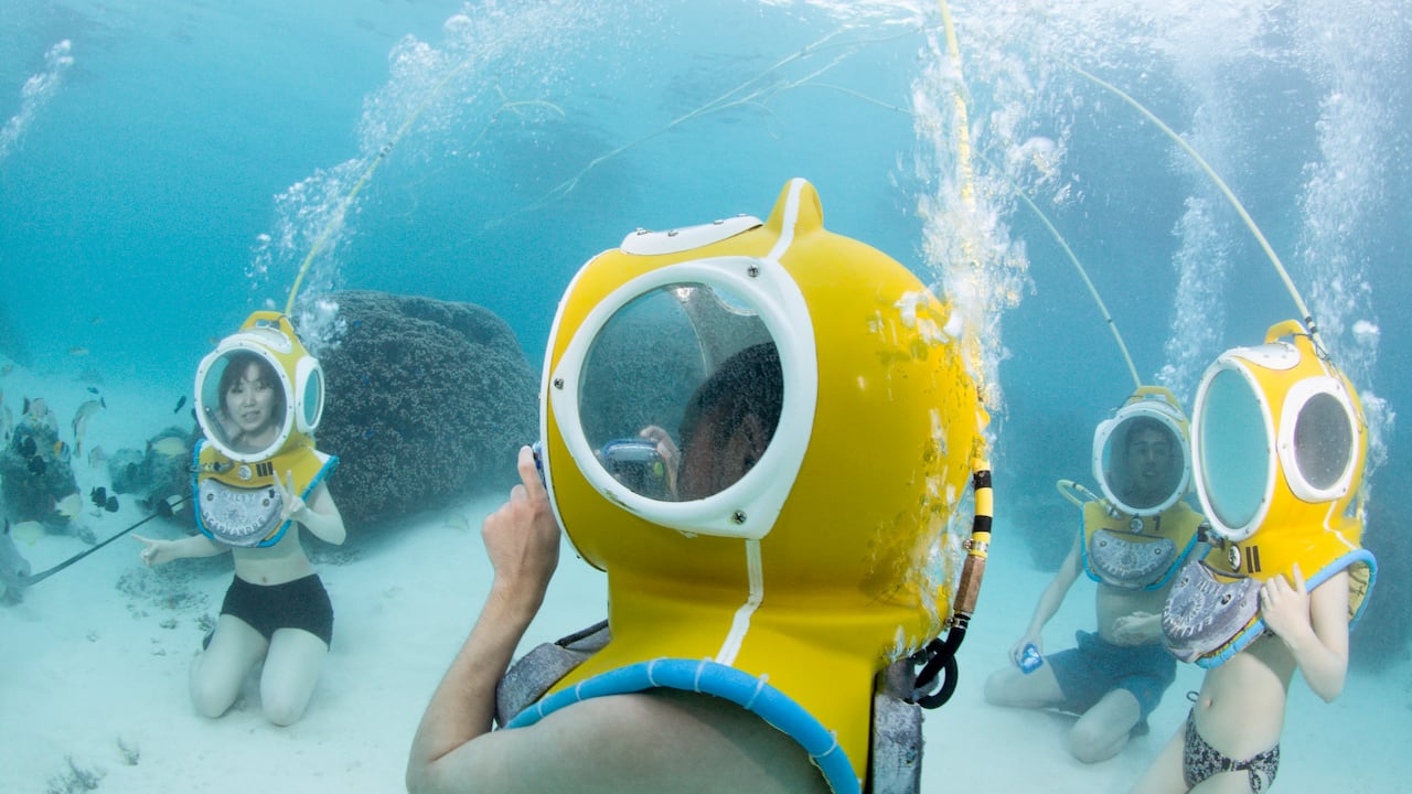 Turistas caminando bajo el mar.