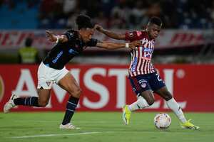 Deiber Caicedo del Junior de Colombia, derecha, y Ricardo Ade de la Liga Deportiva Universitaria de Ecuador, luchan por el balón durante un partido de fútbol del Grupo D de la Copa Libertadores en el Estadio Metropolitano
