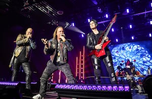 Los cantantes de Helloween, Michael Kiske y Andi Deris, en escena junto al guitarrista Sascha Gerstner, en su gira de aniversario. Foto: Oliver Berg/picture alliance vía Getty Images.