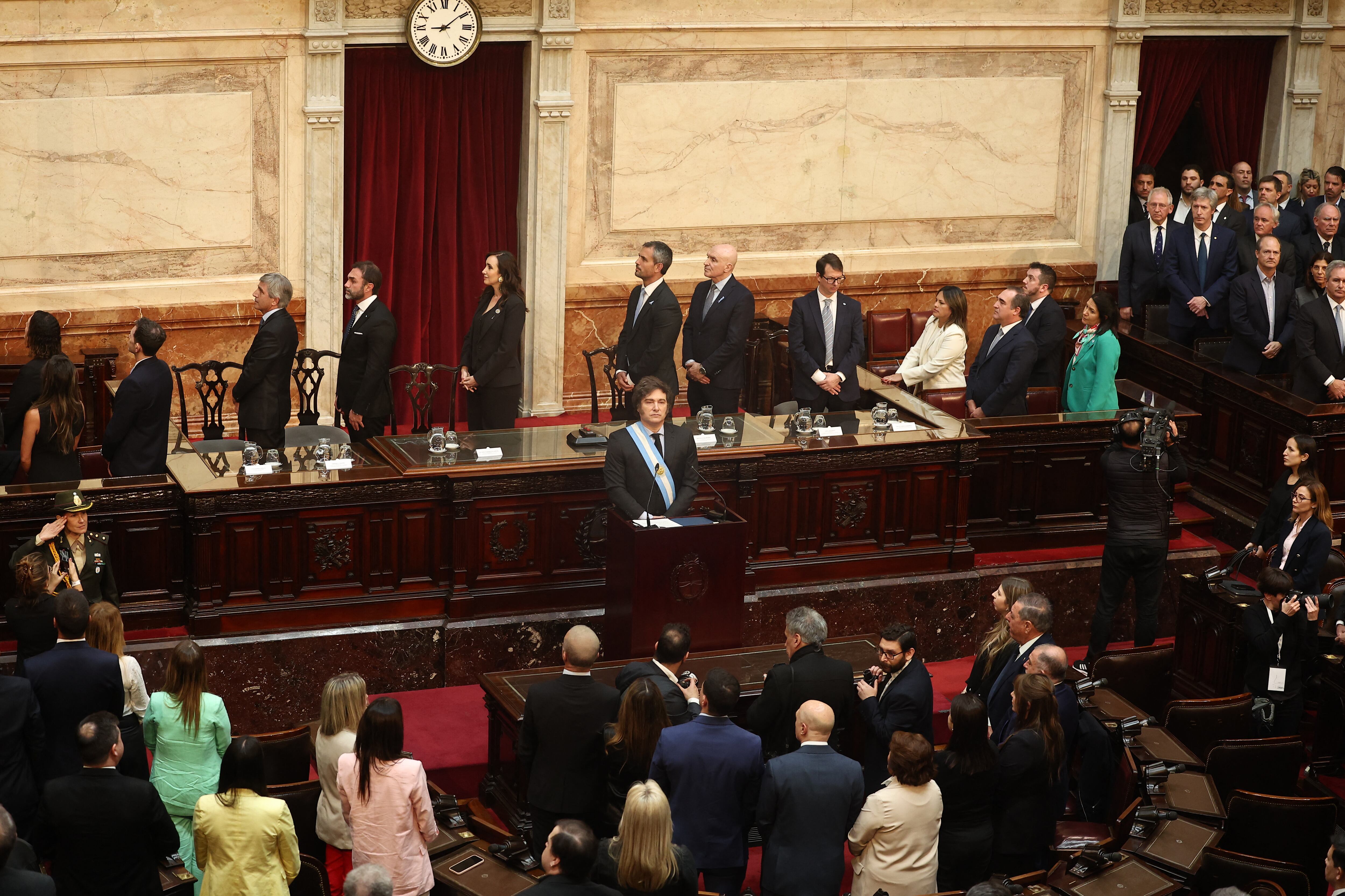 El presidente de Argentina, Javier Milei (centro), escucha el himno nacional antes de la presentación de la propuesta de presupuesto para 2025 al Congreso en Buenos Aires el 15 de septiembre de 2024. (Foto de ALEJANDRO PAGNI / AFP)