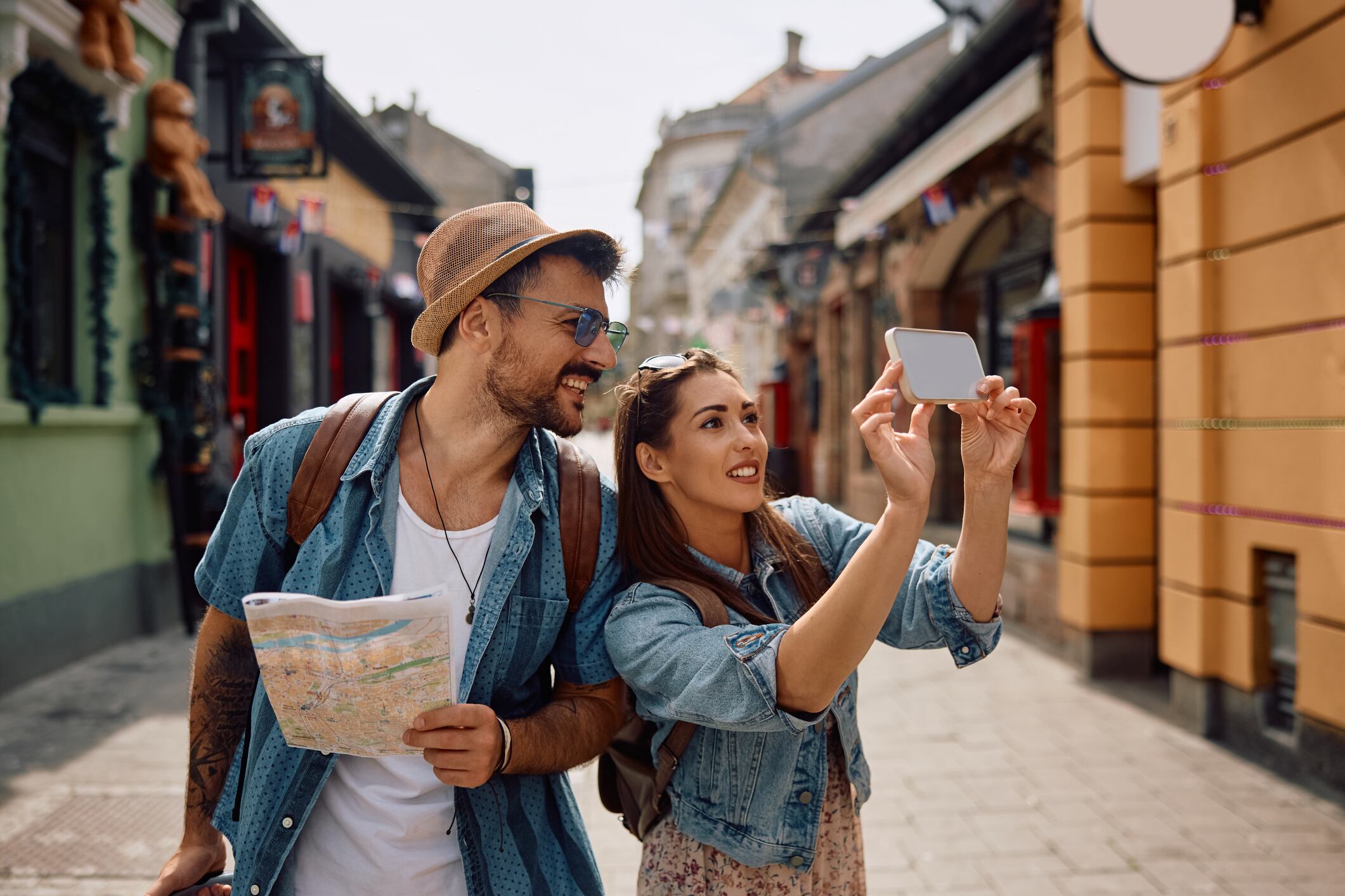 Happy woman and her boyfriend taking selfie with cell phone while traveling together.
