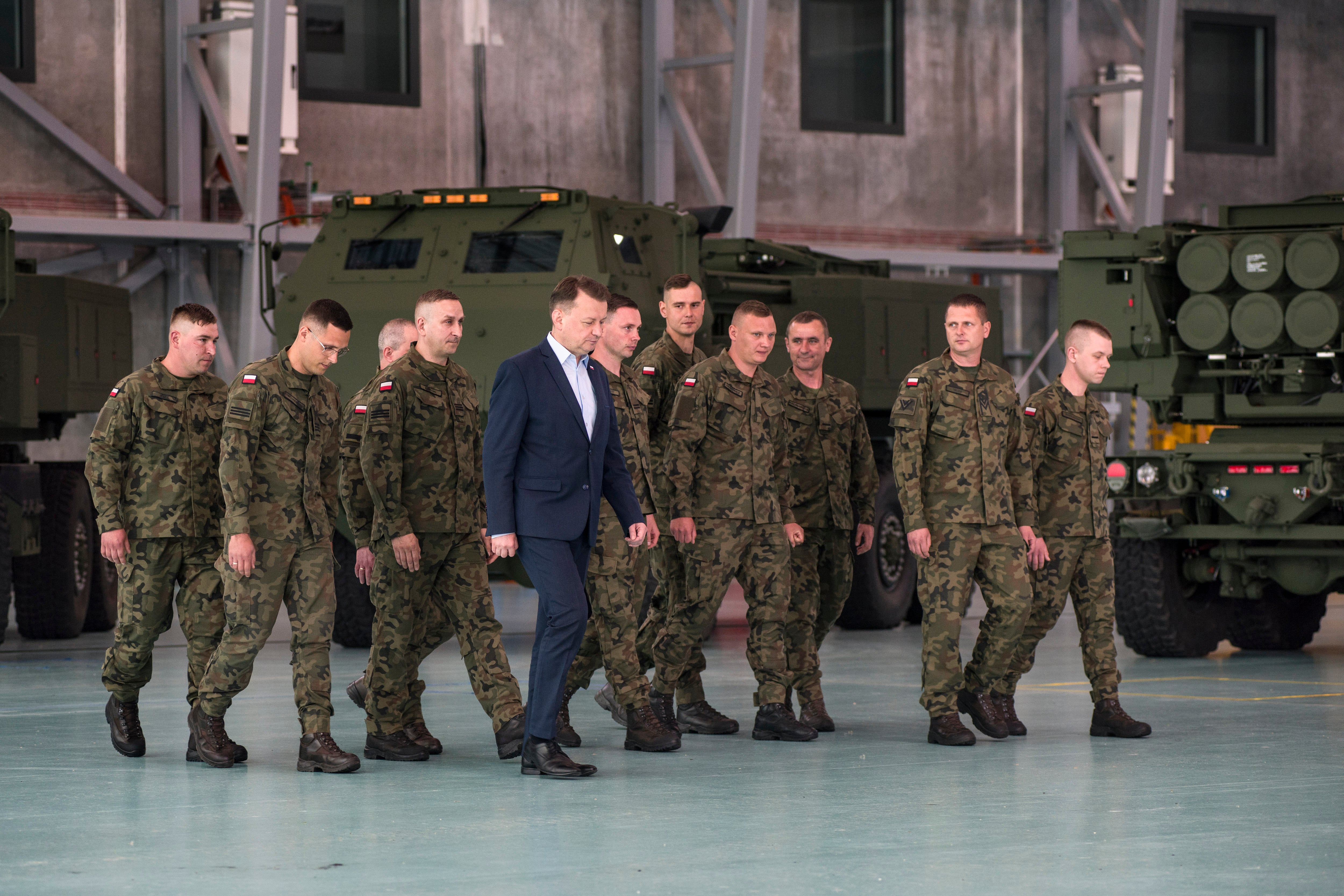 El Ministro polaco de Defensa Nacional, Mariusz Blaszczak (C), es visto con la asistencia de militares polacos durante la ceremonia en la 1ra base militar de aviación de transporte en Varsovia.