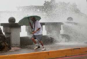 Un hombre corre para alejarse de las olas mientras camina junto a la orilla en Kaohsiung, Taiwán, el miércoles 2 de octubre de 2024, antes de la llegada del tifón Krathon a la zona. (AP Foto/Chiang Ying-ying)