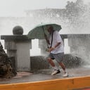 Un hombre corre para alejarse de las olas mientras camina junto a la orilla en Kaohsiung, Taiwán, el miércoles 2 de octubre de 2024, antes de la llegada del tifón Krathon a la zona. (AP Foto/Chiang Ying-ying)