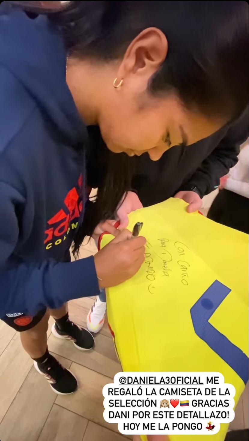 Daniela Arias firmando la camiseta de Daniella Álvarez.