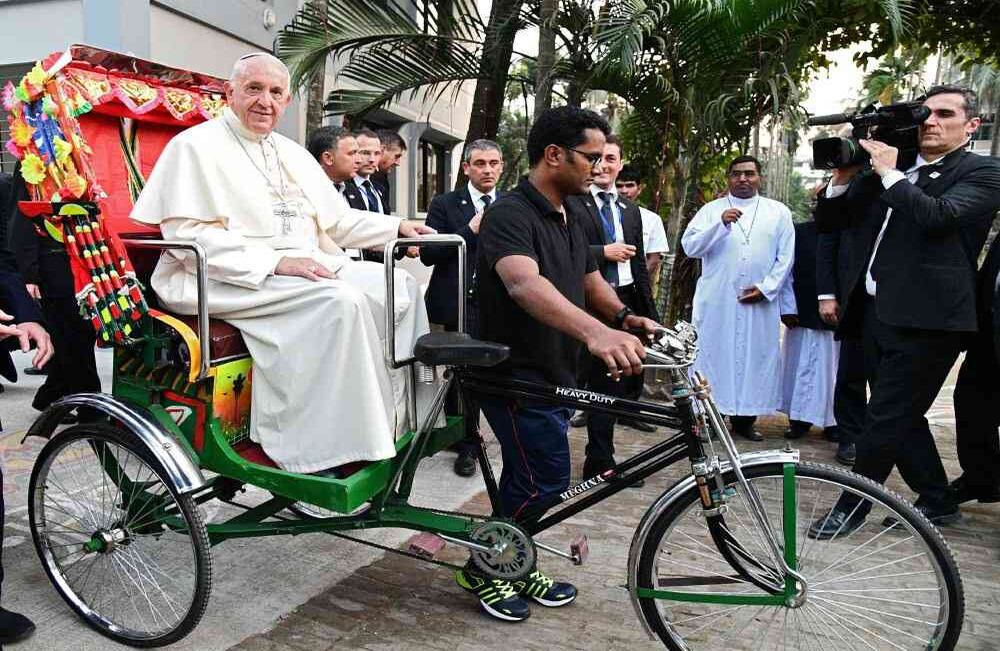 El Papa Francisco viaja en un rickshaw durante su segunda visita a Bangladesh, en Dhaka, el 1 de diciembre de 2017. El Papa Francisco llegó a Bangladesh desde Myanmar el 30 de noviembre para la segunda etapa de una visita que ha sido ensombrecida por los cientos de miles de refugiados Rohingya. / AFP PHOTO / Vincenzo PINTO 