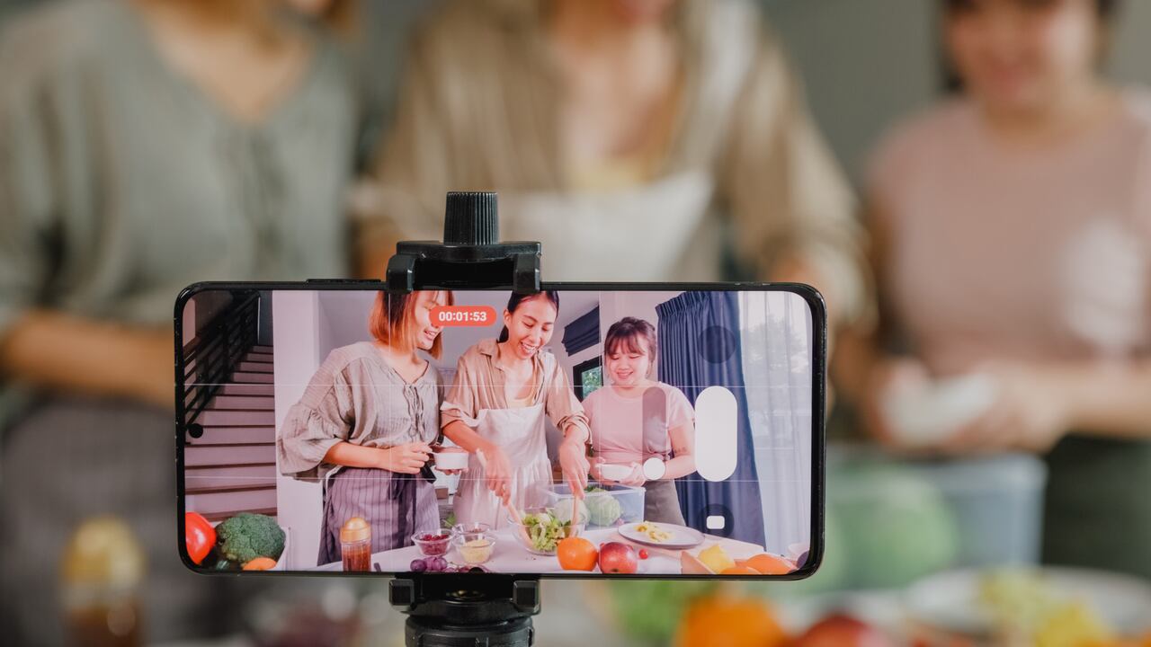 Primer plano de jóvenes amigas asiáticas vlogger influencer en línea grabando contenido de video cocinando ensalada en la cocina de casa. Imagen de referencia
