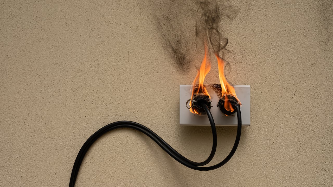 On fire electric wire plug Receptacle on the concrete wall background