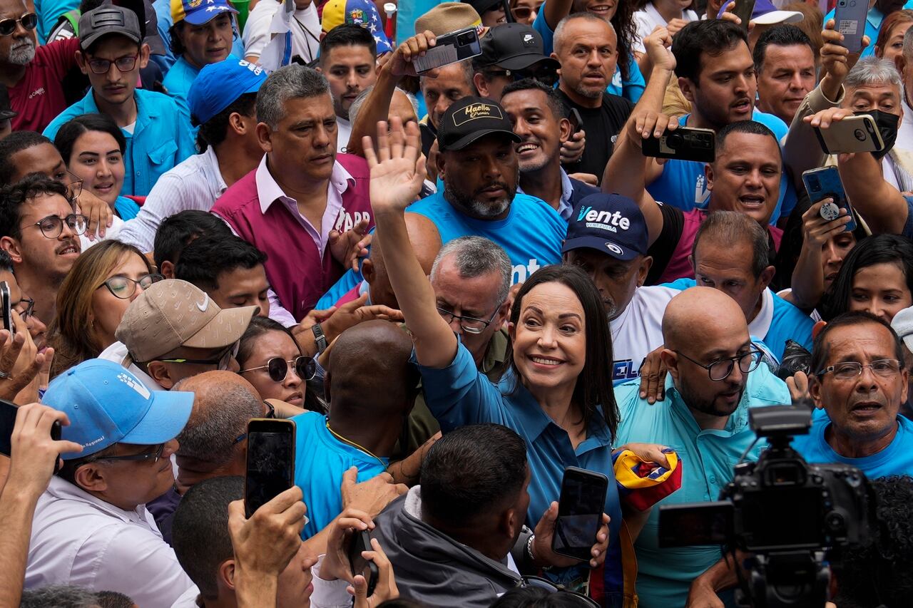 La líder opositora María Corina Machado saluda a sus simpatizantes mientras camina hacia una oficina para inscribirse para participar en las elecciones primarias de la oposición en Caracas, Venezuela, el viernes 23 de junio de 2023. (AP Foto/Ariana Cubillos)