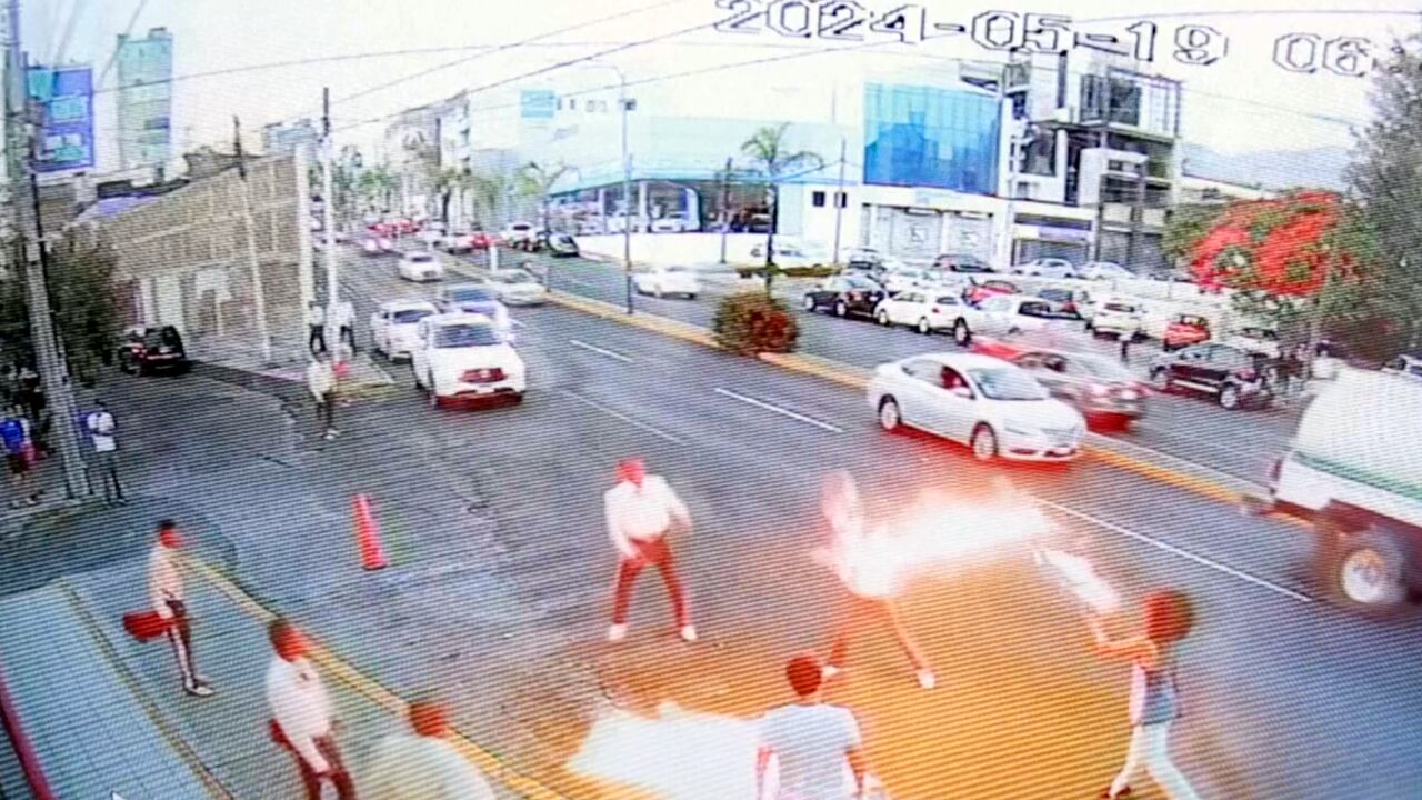 En esta imagen tomada de un video proporcionado por Jorge Toscano, un tragafuego (en la derecha) se enfrenta a unos mariachis con guitarras, el domingo 19 de mayo de 2024, en Morelia, México. (Jorge Toscano via AP)