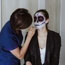 Mujer haciendo maquillaje de catrina.