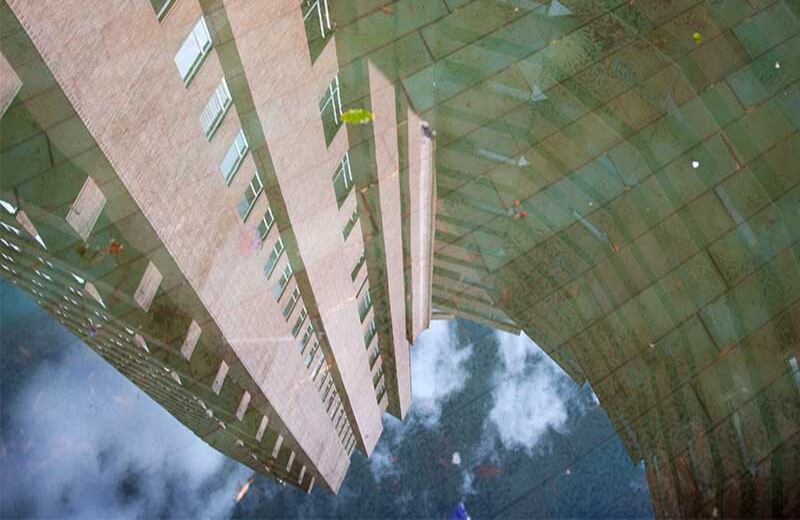 El espejo de agua que hay en la parte baja de la torre sur de Las Torres del Parque, reconocida como una de las mejores obras arquitectónicas latinoamericanas, es un rincón al que casi nadie entra, pero en el que al mediodía se puede ver sobre el agua el reflejo entero del edificio. En este espacio, Hernando Gómez, durante sus recorridos, les demuestra a los caminantes que la belleza no siempre está en lo grandilocuente. Foto: David Amado-Semana. 