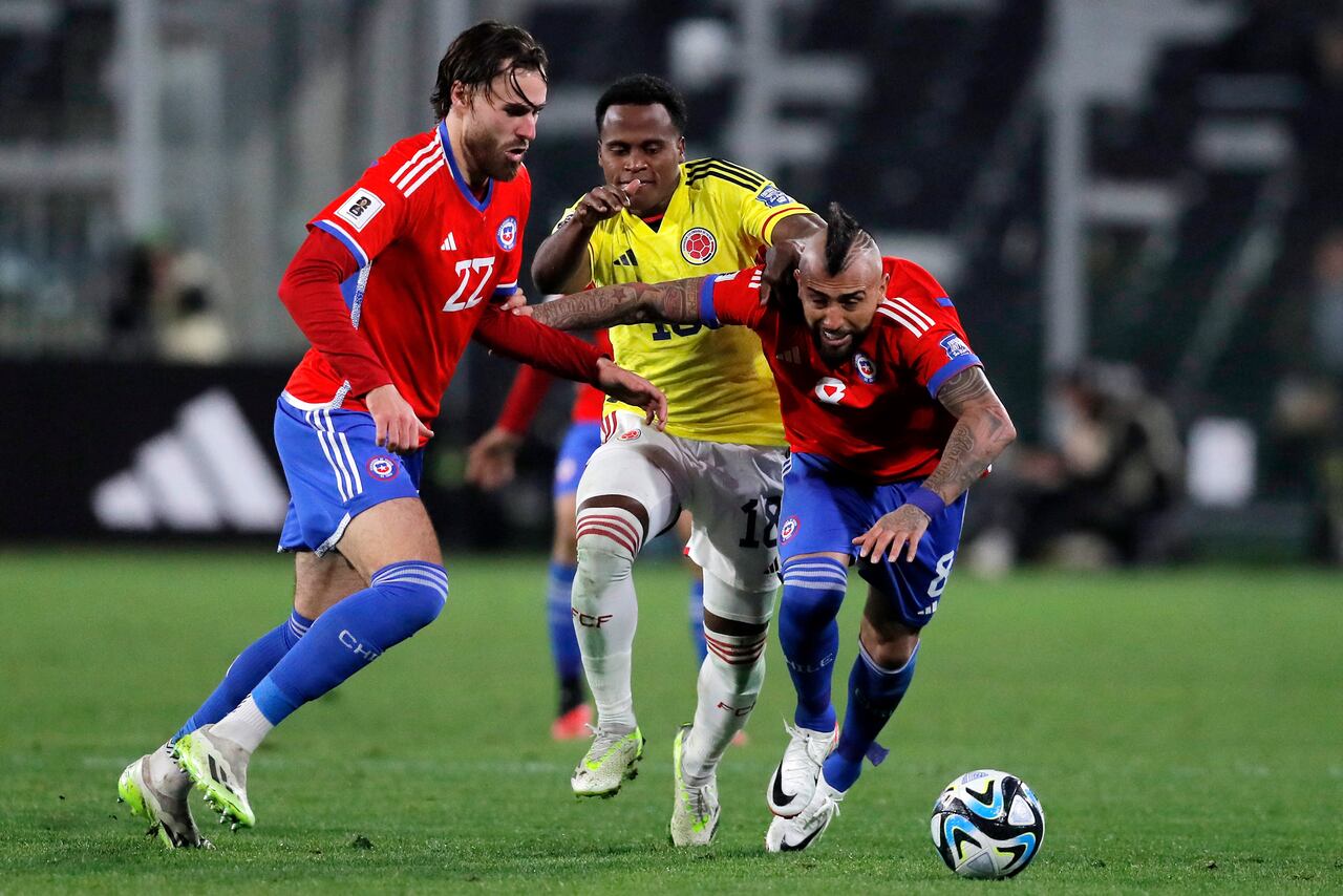 Colombia's midfielder Jhon Arias (C) fights for the ball with Chile's forward Ben Brereton (L) and midfielder Arturo Vidal during the 2026 FIFA World Cup South American qualifiers football match between Chile and Colombia, at the David Arellano Monumental stadium, in Santiago, on September 12, 2023. (Photo by Javier TORRES / AFP)