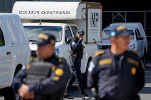Policías hacen guardia mientras agentes de la Fiscalía General allanan una instalación del Tribunal Supremo Electoral en la Ciudad de Guatemala, el martes 12 de septiembre de 2023. (AP Foto/Moisés Castillo)