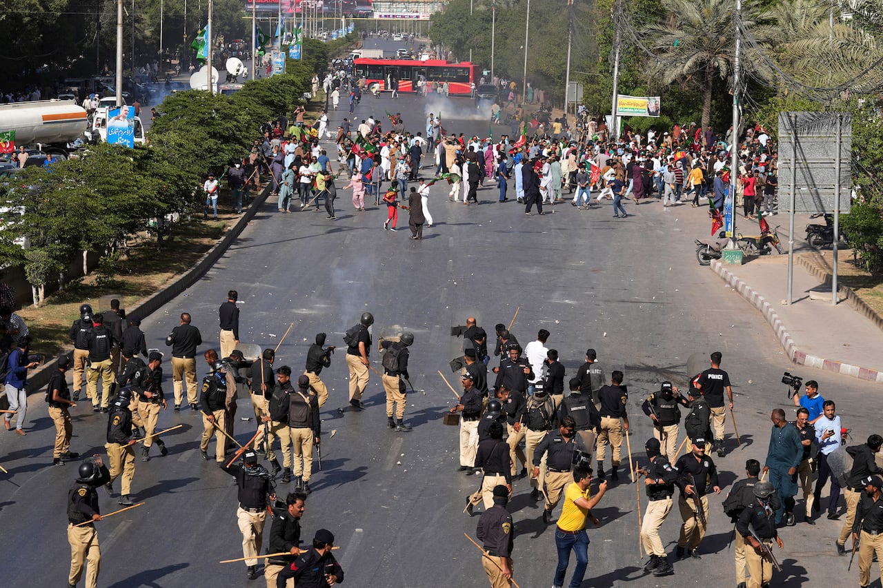 Oficiales de policía y simpatizantes del ex primer ministro de Pakistán, Imran Khan, intercambian piedras durante una protesta contra el arresto de Khan