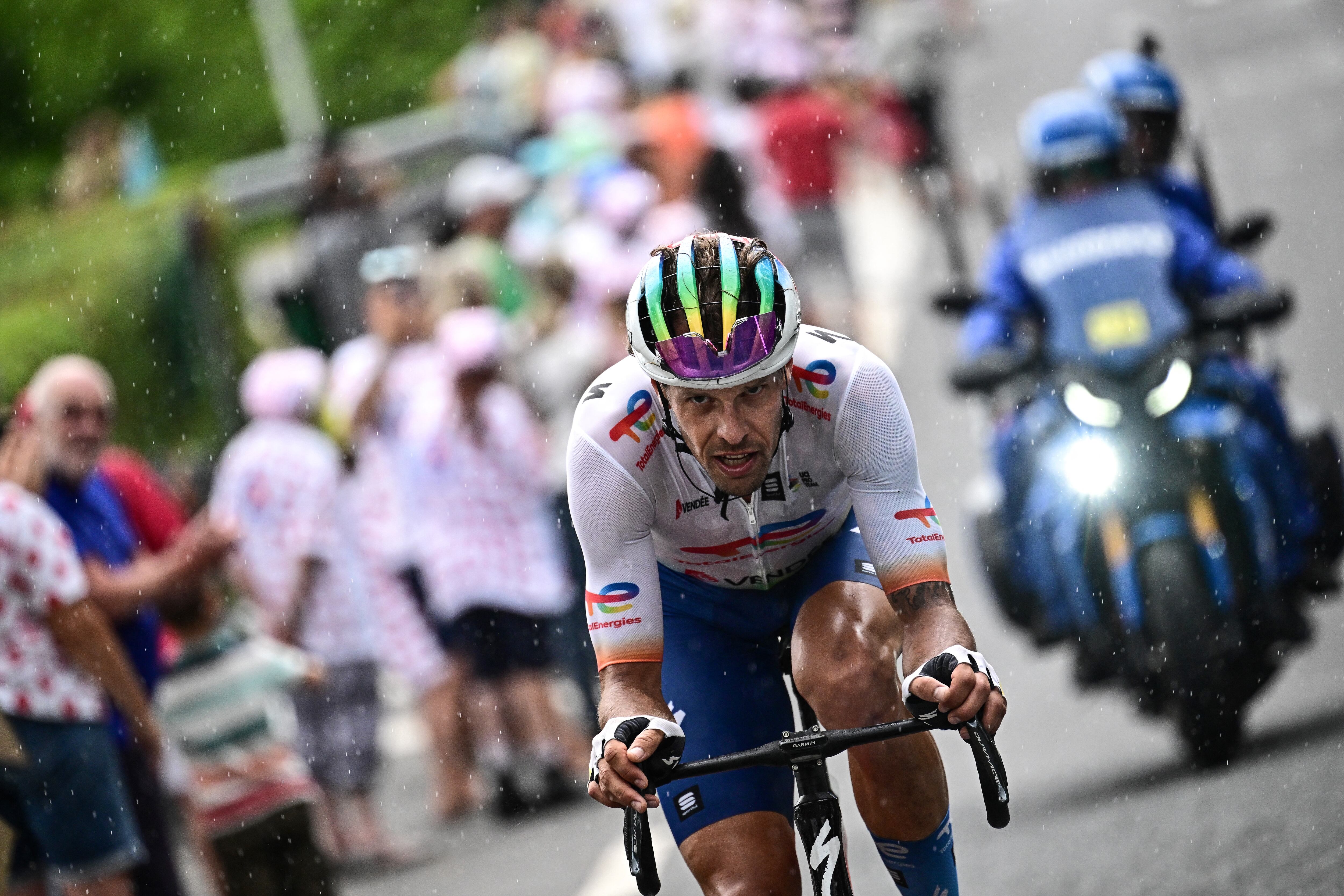 TotalEnergies' Italian rider Daniel Oss cycles in the rain, in a lone breakaway ahead of the pack of riders during the 11th stage of the 110th edition of the Tour de France cycling race, 180 km between Clermont-Ferrand and Moulins, in central France, on July 12, 2023. (Photo by Marco BERTORELLO / AFP)