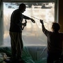 Slava Chikov, a la izquierda, cubre la ventana reventada de su salón con un plástico, en edificio dañado por una bomba el día anterior, en Kiev, Ucrania, el lunes 21 de marzo de 2022. Imagen de referencia. Foto: AP Foto/Vadim Ghirda.