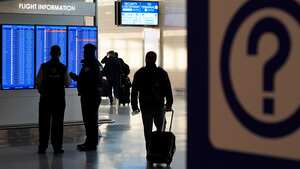 People look at a video display showing flight delays and cancellations at Ronald Reagan Washington National Airport in Arlington, Va., Wednesday, Jan. 11, 2023. (AP Photo/Patrick Semansky)