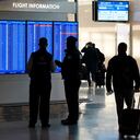 People look at a video display showing flight delays and cancellations at Ronald Reagan Washington National Airport in Arlington, Va., Wednesday, Jan. 11, 2023. (AP Photo/Patrick Semansky)